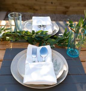 un tavolo con piatti, forchette e tovaglioli di Hollicarrs - Bluebell Lodge a Riccall