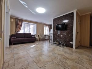 a living room with a couch and a tv on a wall at Chernigov City Centre Apartments in Chernihiv