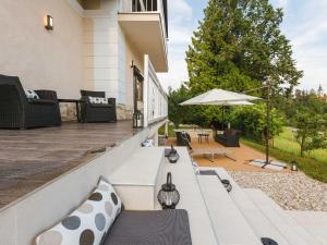 Un patio con sillas y una sombrilla en una casa. en Villa M&J Bled, en Zgornje Gorje