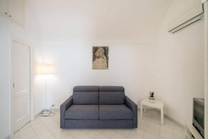un soggiorno con sedia blu e TV di Casa Vacanza Al Centro di Capri a Capri