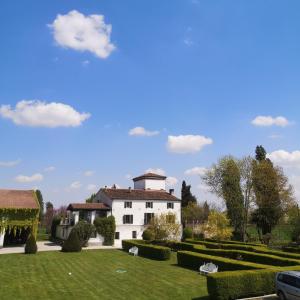 un gran edificio blanco en un parque con patio en Agriturismo Corte Spino, en Nogarole Rocca