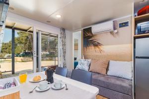 a dining room with a table and a couch at Perla - Lux Mobile Homes in Rovinj