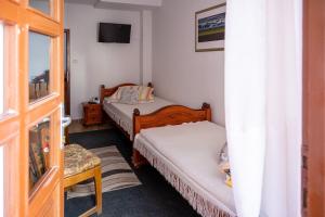a small bedroom with two beds and a window at 2- posteľová izba s kúpeľňou EMKA v PENZION TRSTENÁ in Trstená