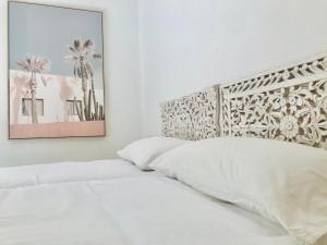 een slaapkamer met een wit bed met een groot hoofdeinde bij CalaLuna Mojácar in Mojácar