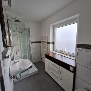a bathroom with a sink and a window at Wohnung "Orther Hafen" in Bannesdorf auf Fehmarn in Fehmarn +15 photos