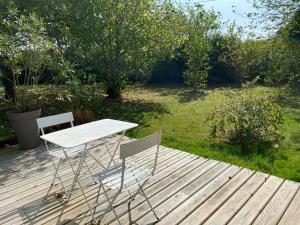 a table and two chairs sitting on a wooden deck at La Chambre de Claire in Les Iffs
