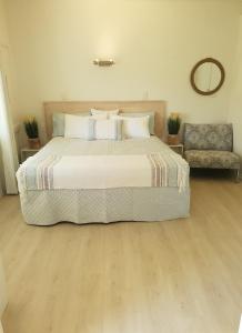 een slaapkamer met een groot bed en een stoel bij Harmony Haven in Nelly Bay