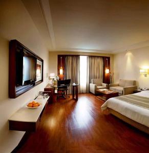 a hotel room with a bed and a living room at Park Inn Gurgaon in Gurgaon +68 photos