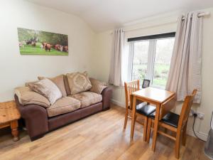 a living room with a couch and a table at Little Pandy Cottage in Mold