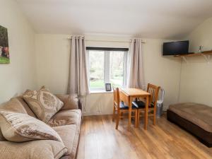 a living room with a couch and a table at Little Pandy Cottage in Mold