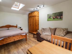a living room with a bed and a couch at Little Pandy Cottage in Mold