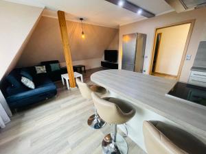 a kitchen and living room with a counter and chairs at EasyStay#3 Comfort Suite Ferienwohnung in Kliniknähe mit Boxspringbett & Netflix in Bad Oeynhausen