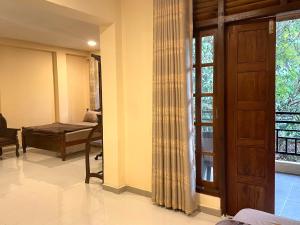 a room with a bedroom with a bed and a window at Hotel mango tree nearest Adam's peak in Nallathanniya +49 photos