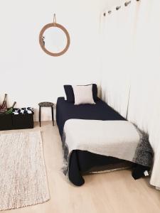 Schlafzimmer mit einem Bett und einem Wandspiegel in der Unterkunft Harmony Haven in Nelly Bay