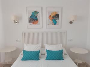 a bedroom with a bed with two tables and two pillows at El Mirador de Marina in Vejer de la Frontera