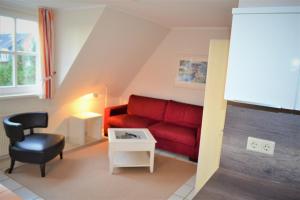 a living room with a red couch and a chair at Nordlicht in Wyk auf Föhr