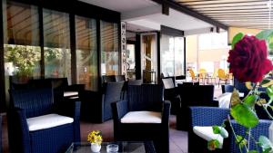 ein Restaurant mit blauen Stühlen und einem Tisch mit einer roten Blume in der Unterkunft Hotel Orchidea in Cesenatico