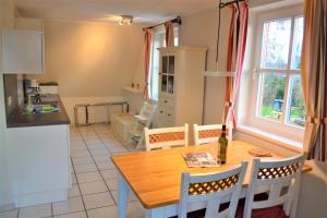 een keuken en eetkamer met een houten tafel bij Nordlicht in Wyk auf Föhr