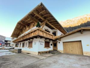 een gebouw met een houten dak en een garage bij Landhaus Lenz in See