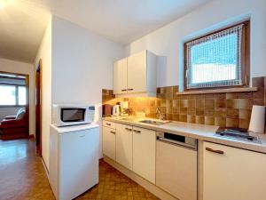 uma cozinha com um frigorífico branco e um micro-ondas em Landhaus Lenz em See
