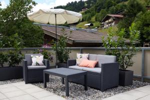 a patio with two chairs and a table and an umbrella at Kramerhaus Viehhofen in Viehhofen