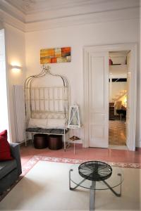 a living room with a bed and a glass table at Suite Il Letto Sotto Il Tetto in Catania