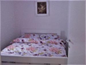 a bed with a floral comforter in a bedroom at Apartment in Rakovica with Wi-Fi (601-3) in Rakovica