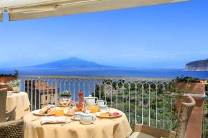 stół z jedzeniem i widokiem na ocean w obiekcie Grand Hotel Capodimonte w Sorrento