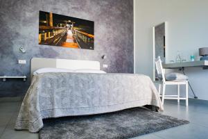 a bedroom with a bed with a picture on the wall at Villa Caravaggio Comfort e Relax in Rocca San Giovanni