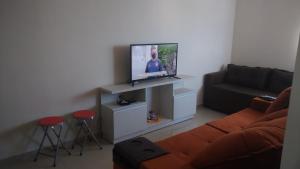 Il comprend un salon doté d'un canapé et d'une télévision à écran plat. dans l'établissement Lindo apartamento frente ao mar., à São José da Coroa Grande
