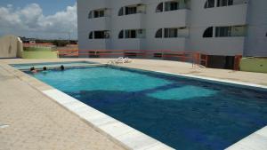 une grande piscine en face d'un bâtiment dans l'établissement Lindo apartamento frente ao mar., à São José da Coroa Grande