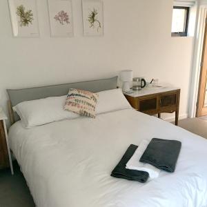 a white bed with a towel on top of it at Uplands Garden in Morecombelake