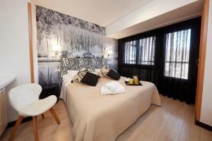 1 dormitorio con 2 camas y una silla blanca en Hotel Sanchez, en Aínsa