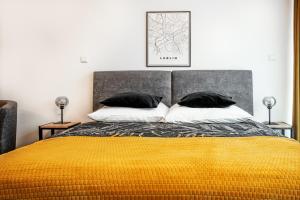 a bedroom with a bed with a yellow blanket and pillows at EASY RENT Apartments - Silver 8, Basen & SPA, Centrum Free Parking 24h Check-in in Lublin