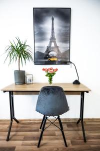 a desk with a chair and a picture of the eiffel tower at EASY RENT Apartments - Silver 8, Basen & SPA, Centrum Free Parking 24h Check-in in Lublin +11 photos
