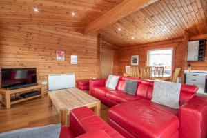 アビモアにあるAviemore Lodgesのリビングルーム(赤いソファ、テレビ付)