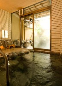 a large pool of water in a room with a window at Izumi-so in Gero
