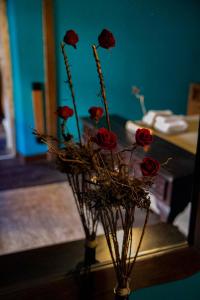 un jarrón lleno de rosas rojas en una habitación en RAICES Casa Rural, en Torre de Don Miguel