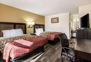 Habitación de hotel con 2 camas y escritorio en Econo Lodge Glade Springs I-81 en Glade Spring