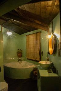 RAICES Casa Rural في Torre de Don Miguel: حمام أخضر مع حوض ومغسلة