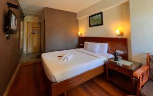 ein Hotelzimmer mit einem Bett mit einem Handtuch darauf in der Unterkunft Hotel Jc Grand in Kodaikanal