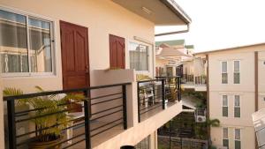 un balcón con puertas marrones y macetas. en Bluebird Inn Pattaya en Pattaya centro