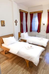 two beds in a room with red curtains at Guest Mansion, Гостински Палат in Rostuša