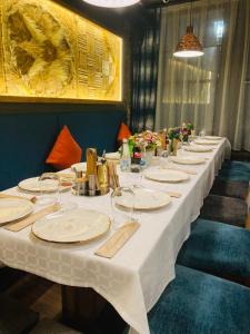 a long table with white plates and wine glasses at Соколови къщи in Gabrovo