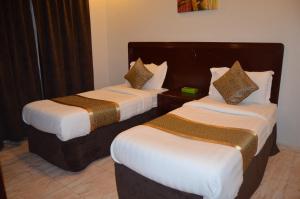 Habitación de hotel con 2 camas con sábanas blancas en دانات الخليج, en Al Khobar