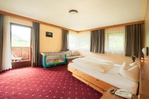 - une chambre avec 2 lits et un lit bébé dans l'établissement Hotel Steuxner, à Neustift im Stubaital