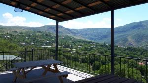 a picnic table on a balcony with a view of mountains at Camping 3 Gs in Goghtʼ