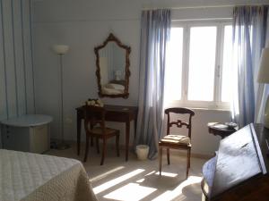 a bedroom with a bed and a desk and a mirror at Le Sirene in Tellaro