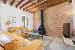 a living room with a couch and a fireplace at NEW! VILLA Can Rito PARA 16 PERSONAS, PISCINA, JARDINES y RELAX in Felanitx