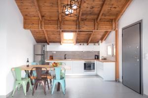 a kitchen with a wooden ceiling and a table and chairs at PanoramiKos in Asfendioú